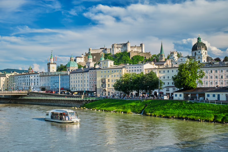 Luxury river cruise sailing past a historic European city during an experiential travel journey